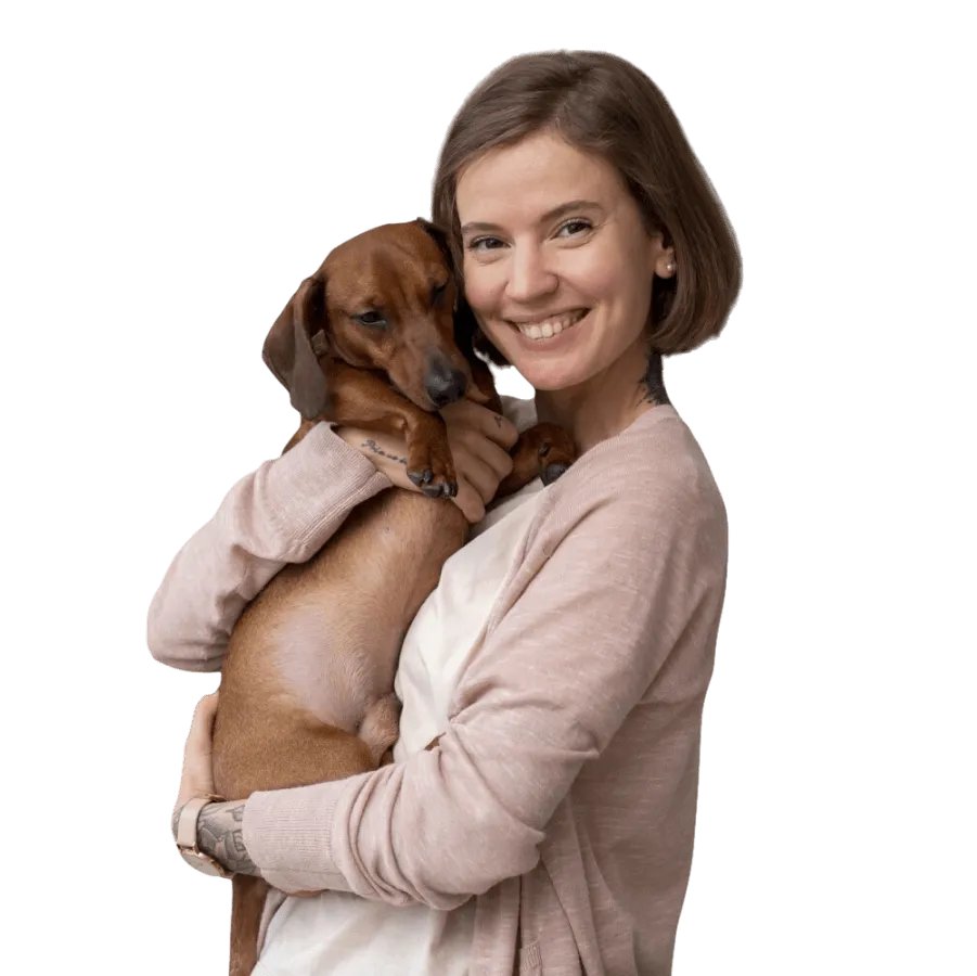 A volunteer holding a rescued dachshund